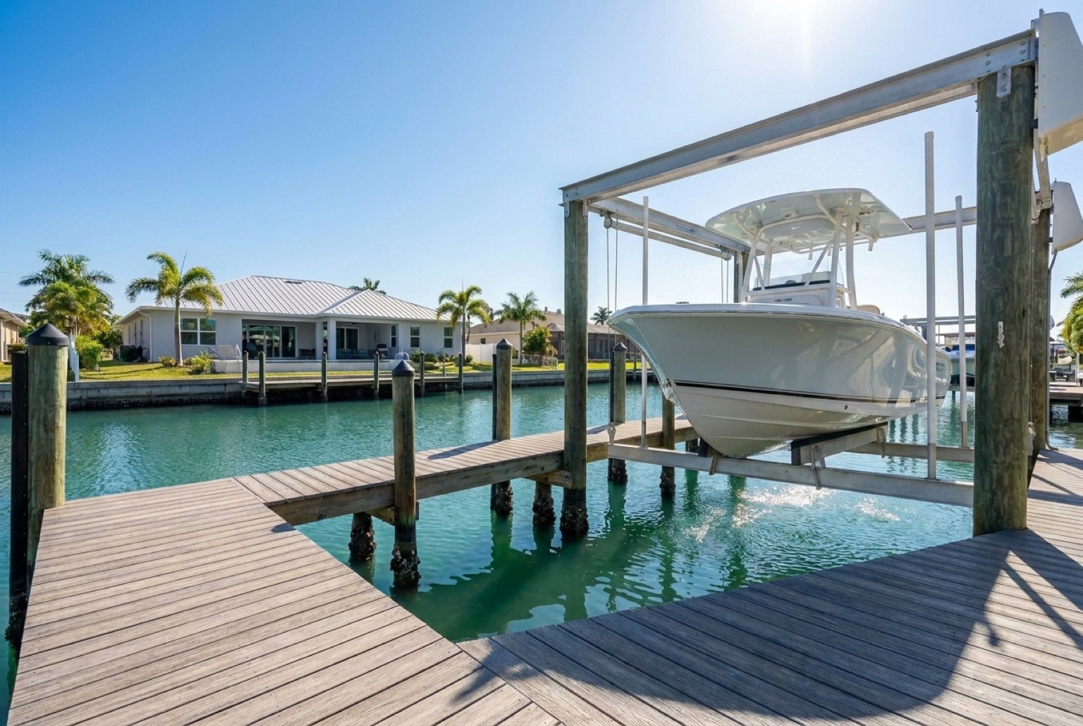 Boat lowered on a lift into a Southwest Florida canal at a residential dock